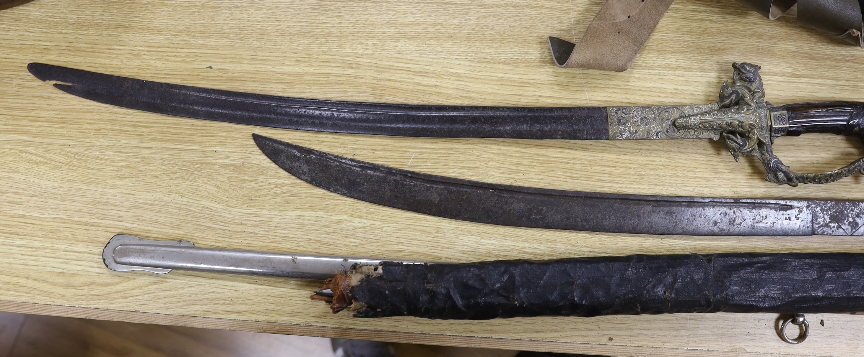 A George V 1897 pattern officer's sword in leather scabbard and canvas outer case with additional steel scabbard, together with a triangular bayonet in leather scabbard with strap and two 19th century Sinhalese swords (k